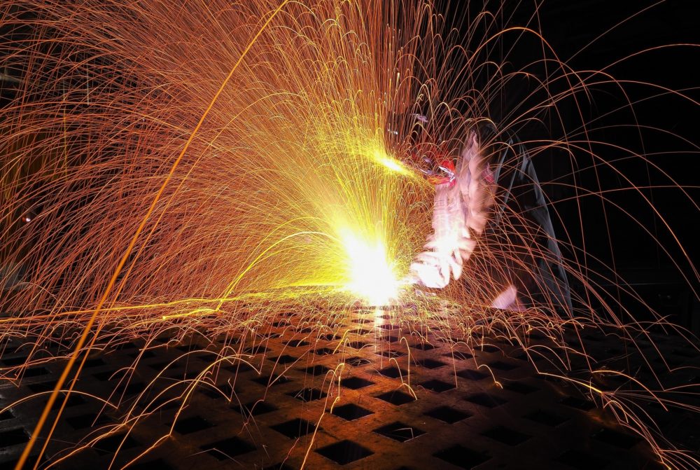A welder welds causing sparks to fly