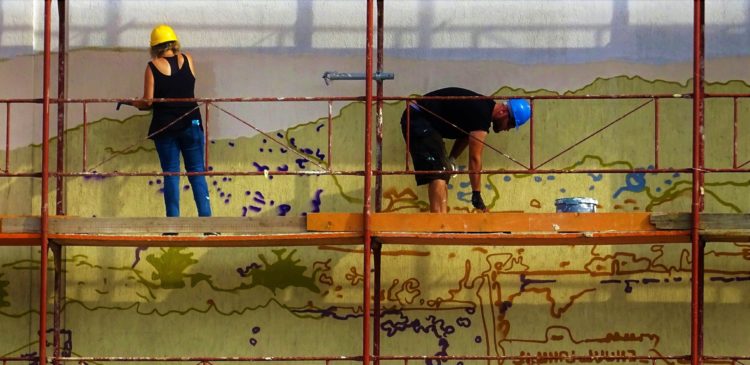 two people painting a mural