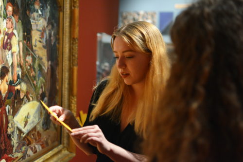 women in front of painting