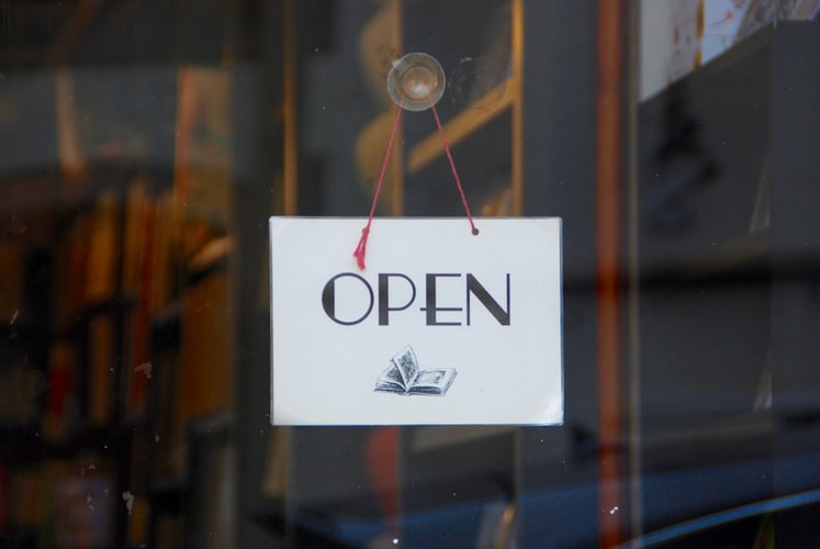 A window sign that says open