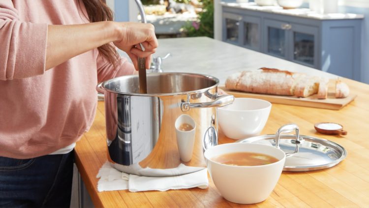 person stirring soup