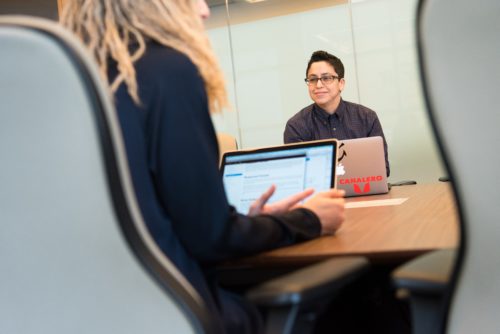 Trustees speaking at a desk